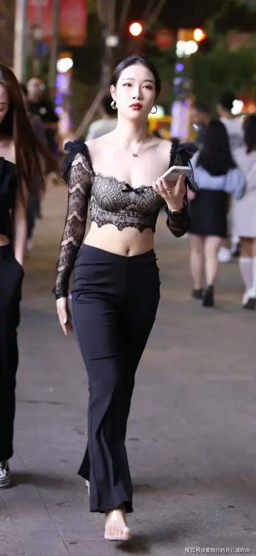 美女身穿黑色蕾丝上衣搭配黑色喇叭裤,优雅时尚,女人味十足
