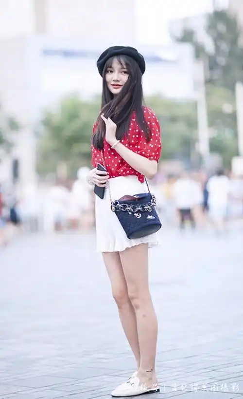 街拍小姐姐穿着白色的短裙,看起来特别的温柔

